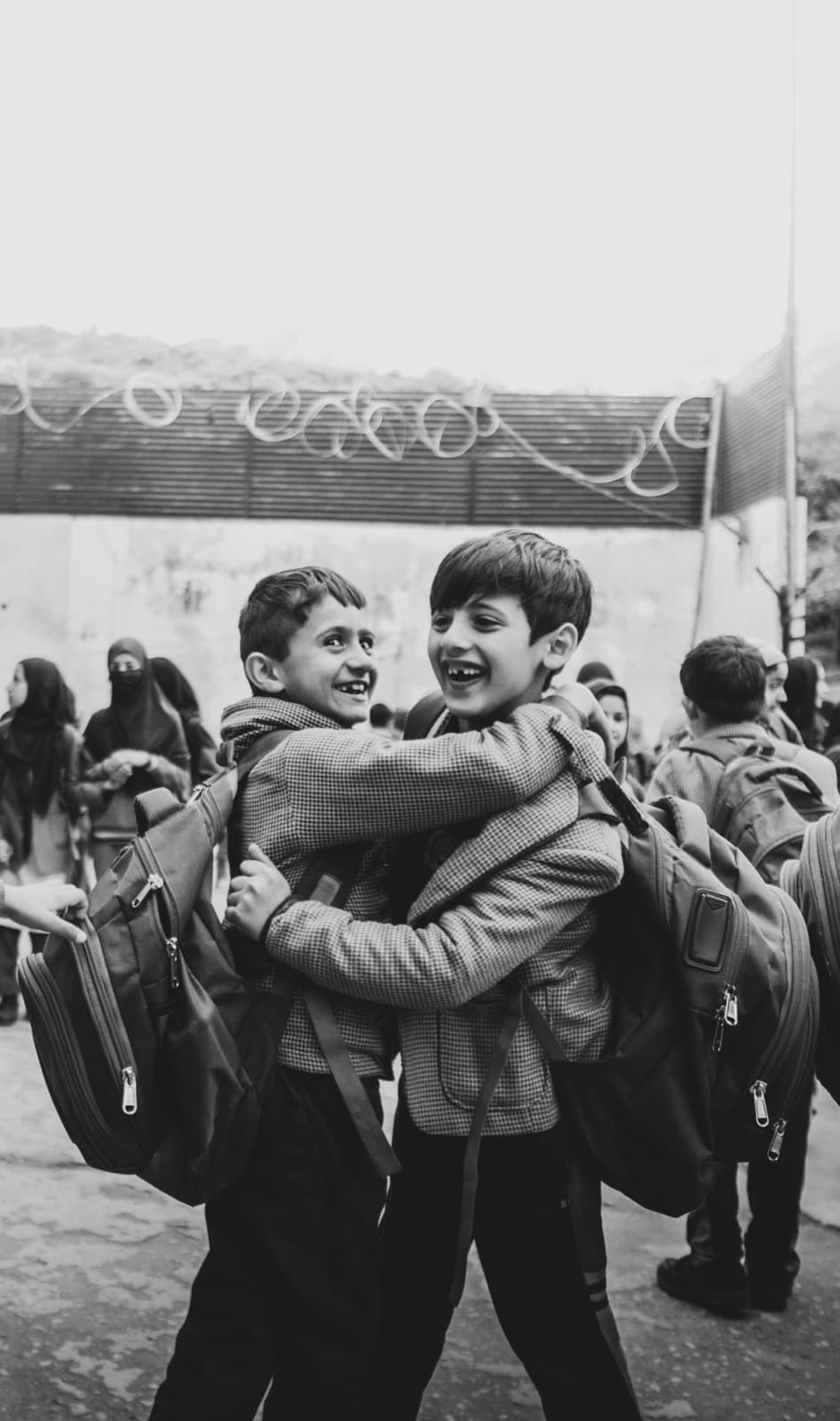 Deux enfants qui se prennent dans les bras à la sortie de l'école