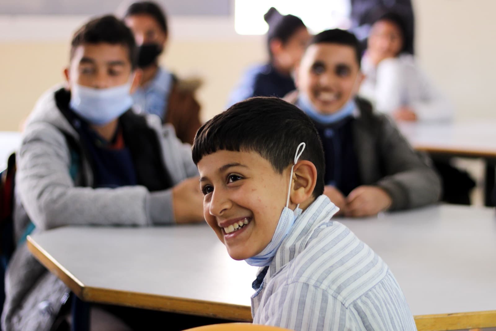 Élève marocain qui sourit en classe, entouré de ses camarades